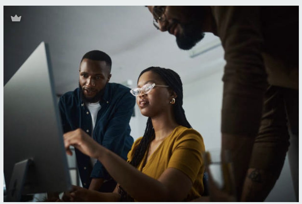 Three engineers working together at a computer